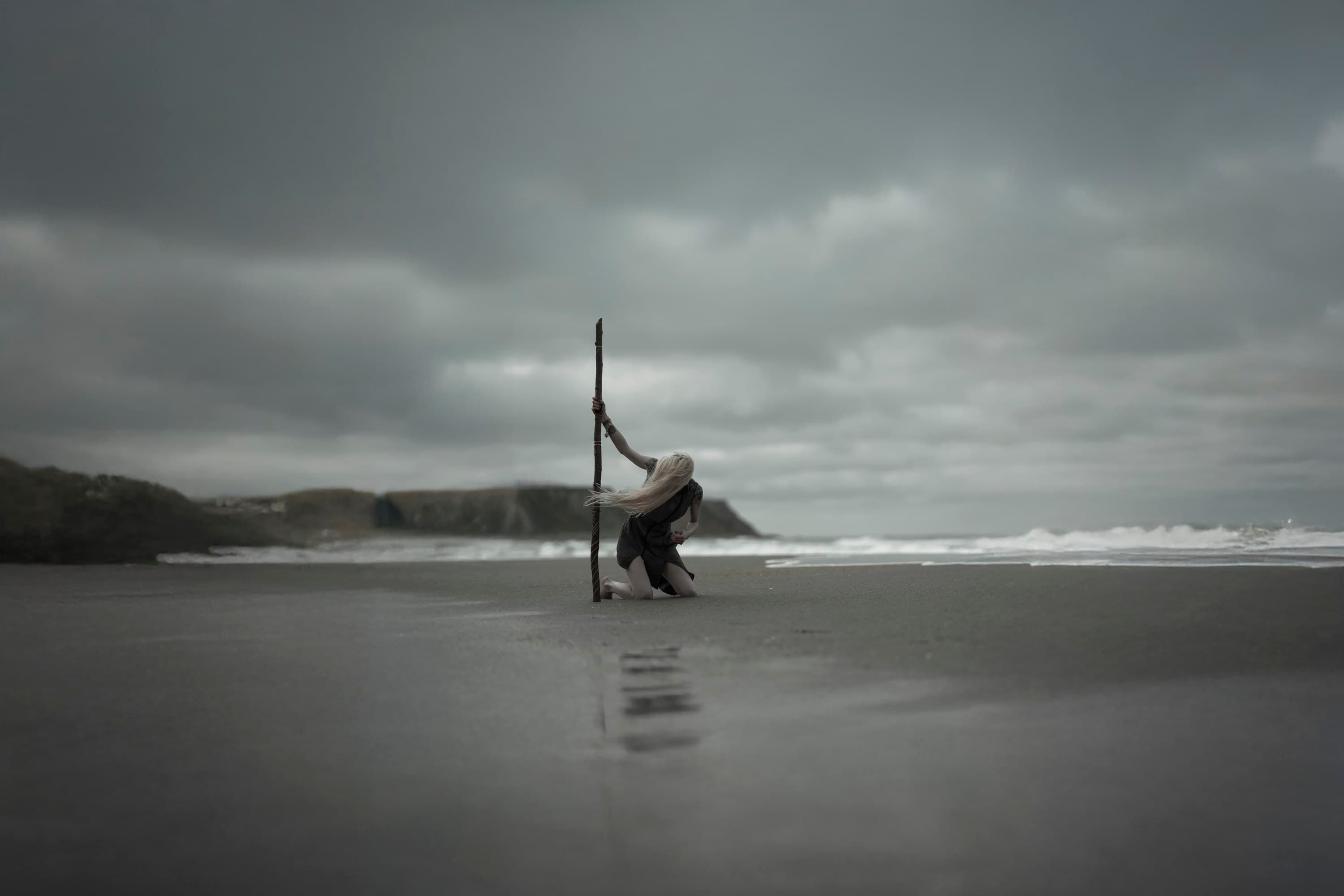 A solitary figure beneath a vast sky on a windswept beach