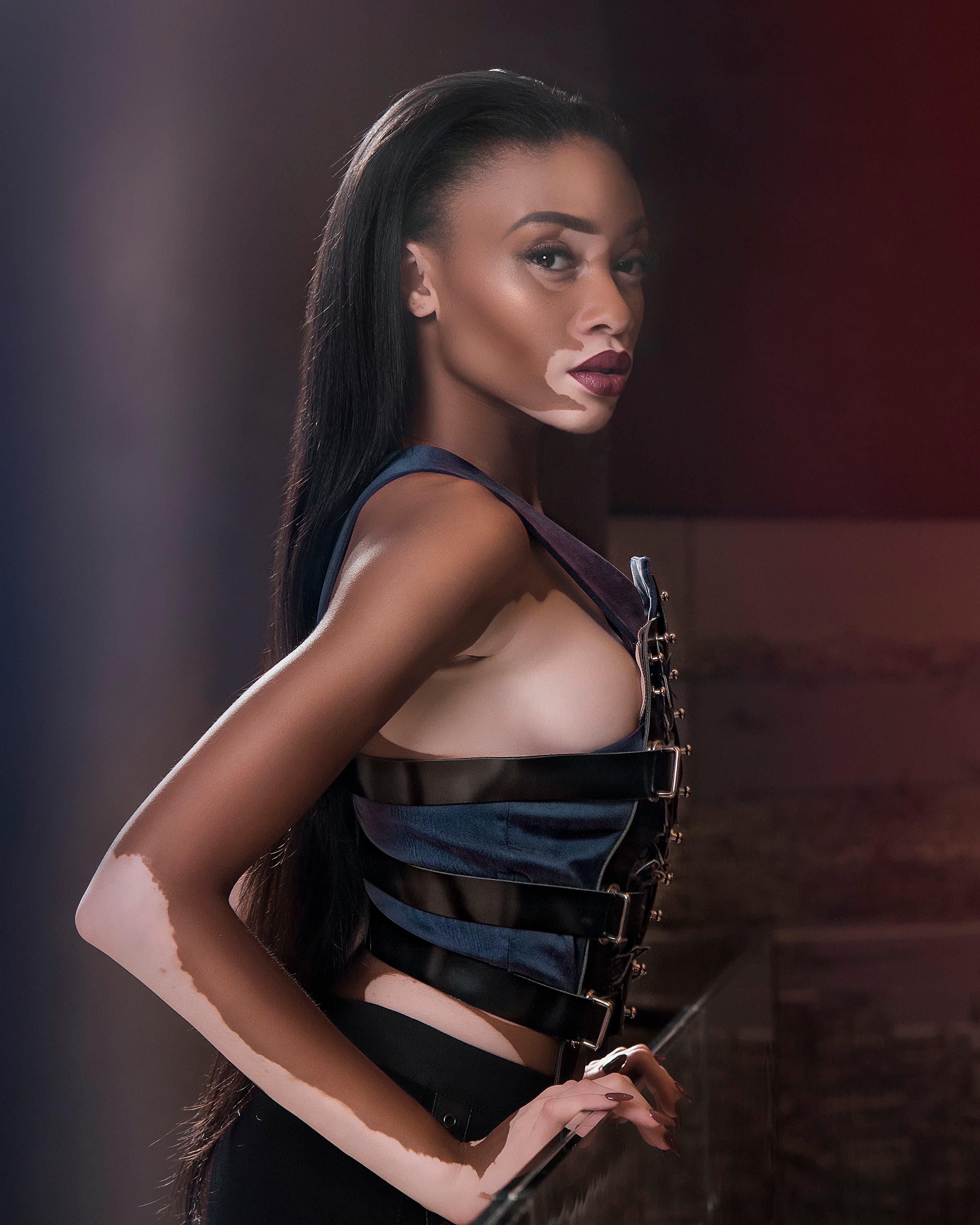 Fashion portrait in a dark dress, framed by soft light
